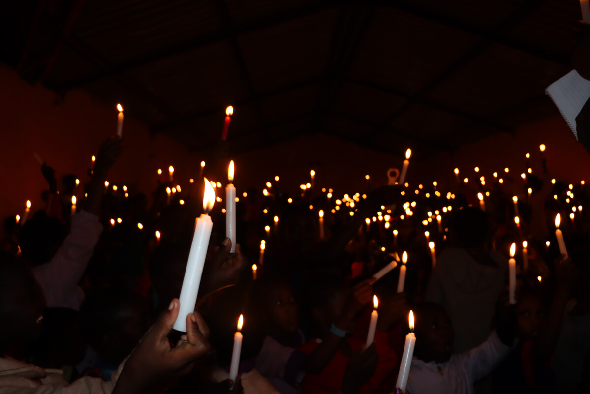 People hold candles at an Alternative Rites of Passage Ceremony in Kajiado, Kenya, 2024. (c) Amref Health Africa/Dennis Ochiel