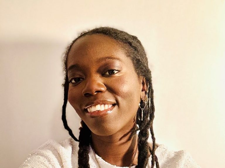 Portrait of Yohanah Rodney, Fundraising Administrator. She's smiling and wearing a white jumper.