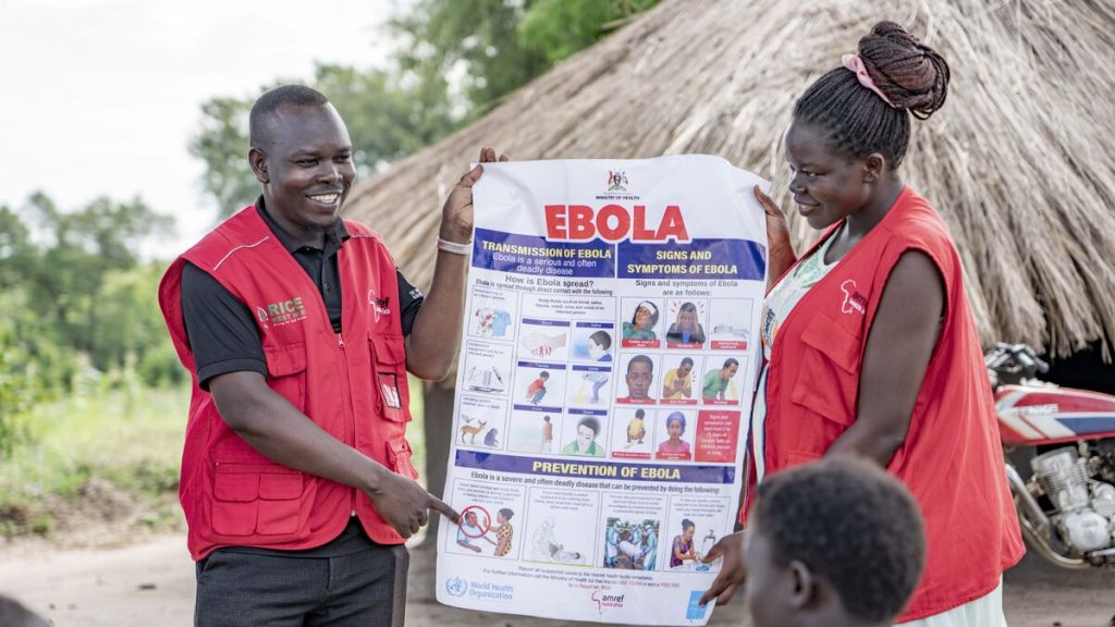 two health workers hold an Ebola information poster in nortehr Uganda, June 2026